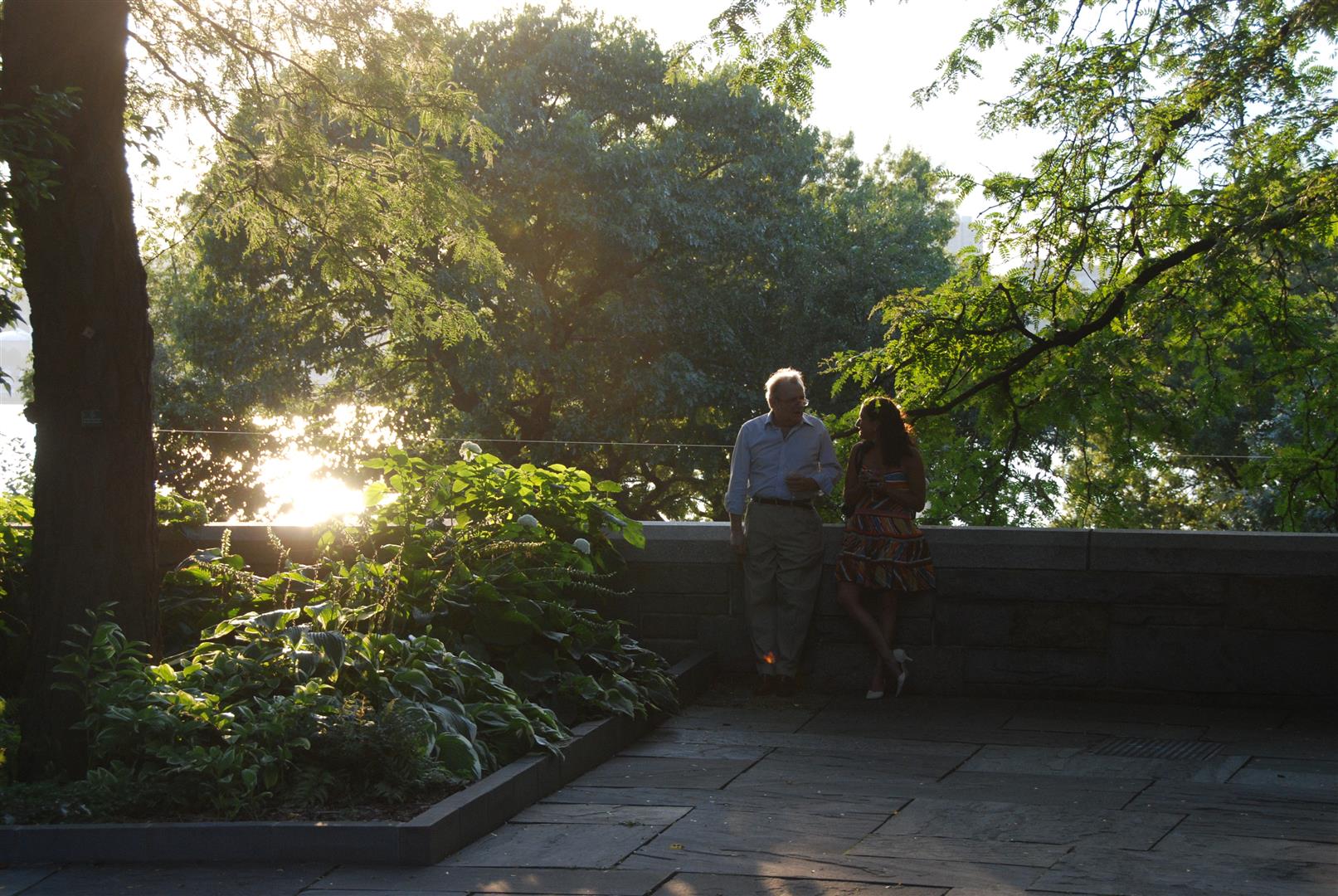 Two people chat in the Park as the sun sets