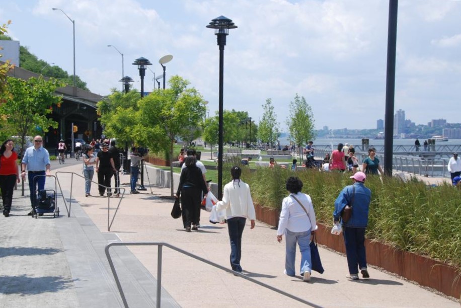 People walk and relax in West Harlem Piers Park