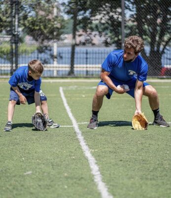 Coach shows kid how to catch a ball