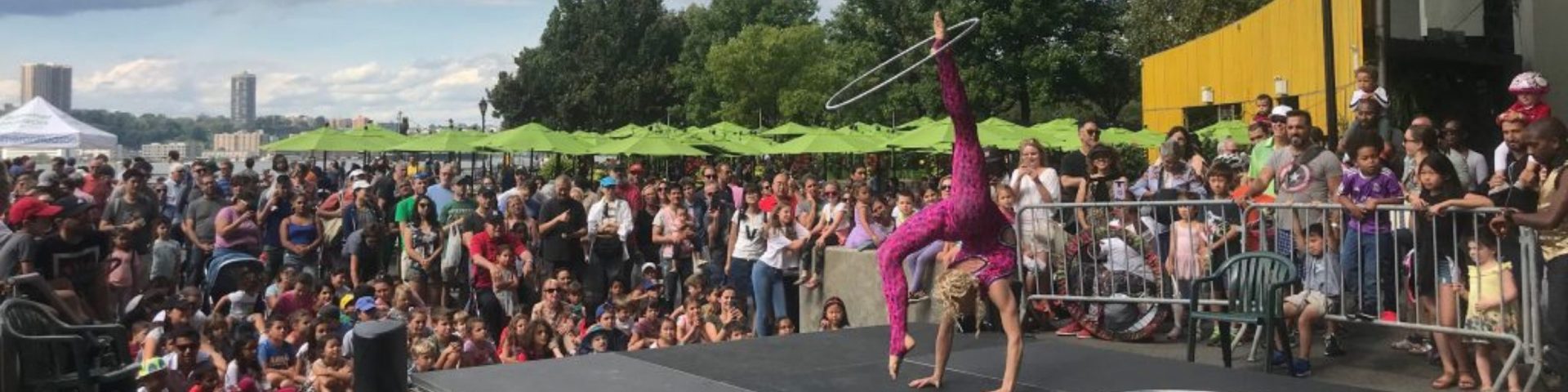 People spectate at an acrobat performance in the Park